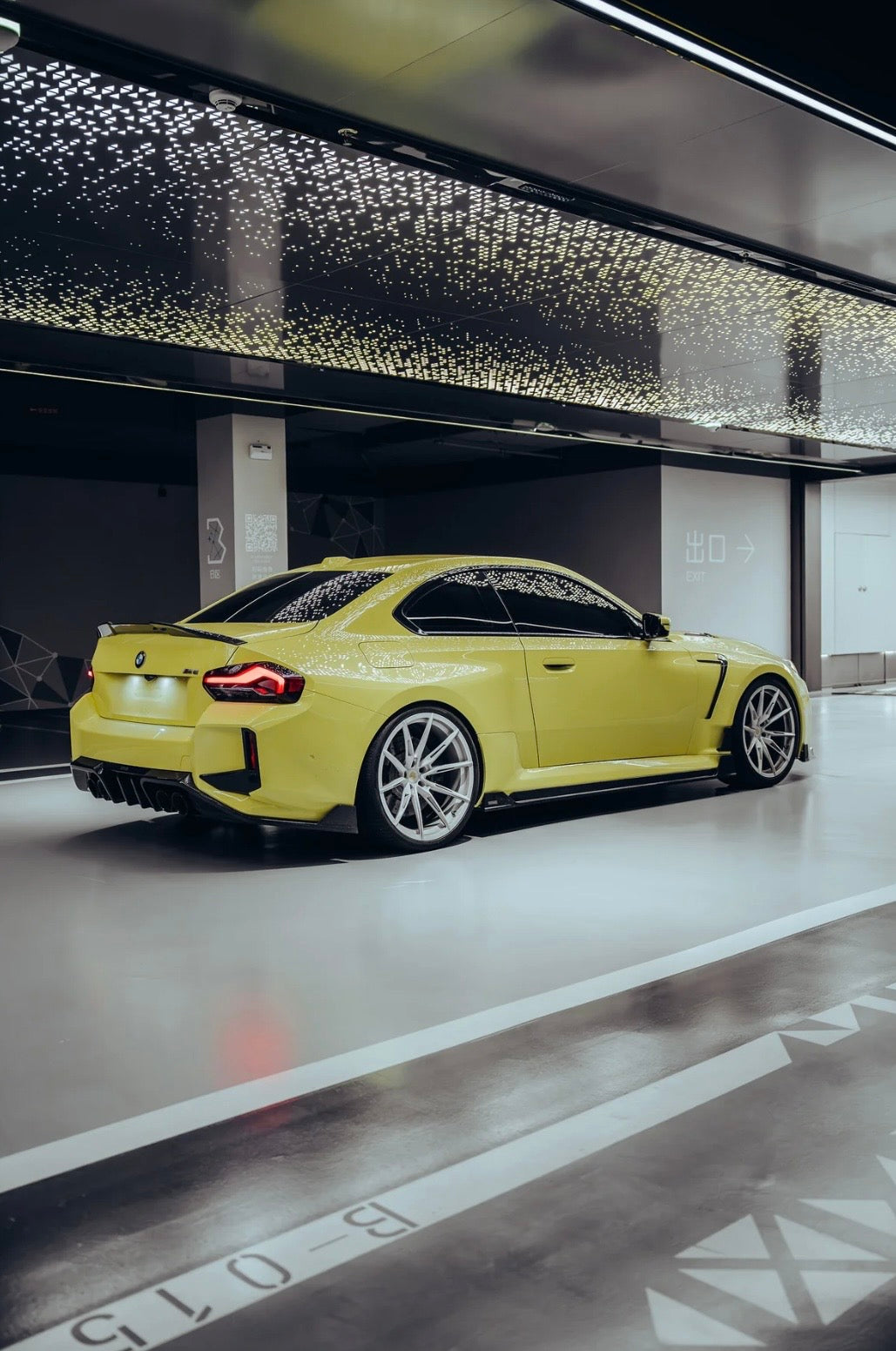 Gelber BMW M2 G87 mit RV V1 Carbon Heckdiffuser – schräge Heckansicht in der Garage