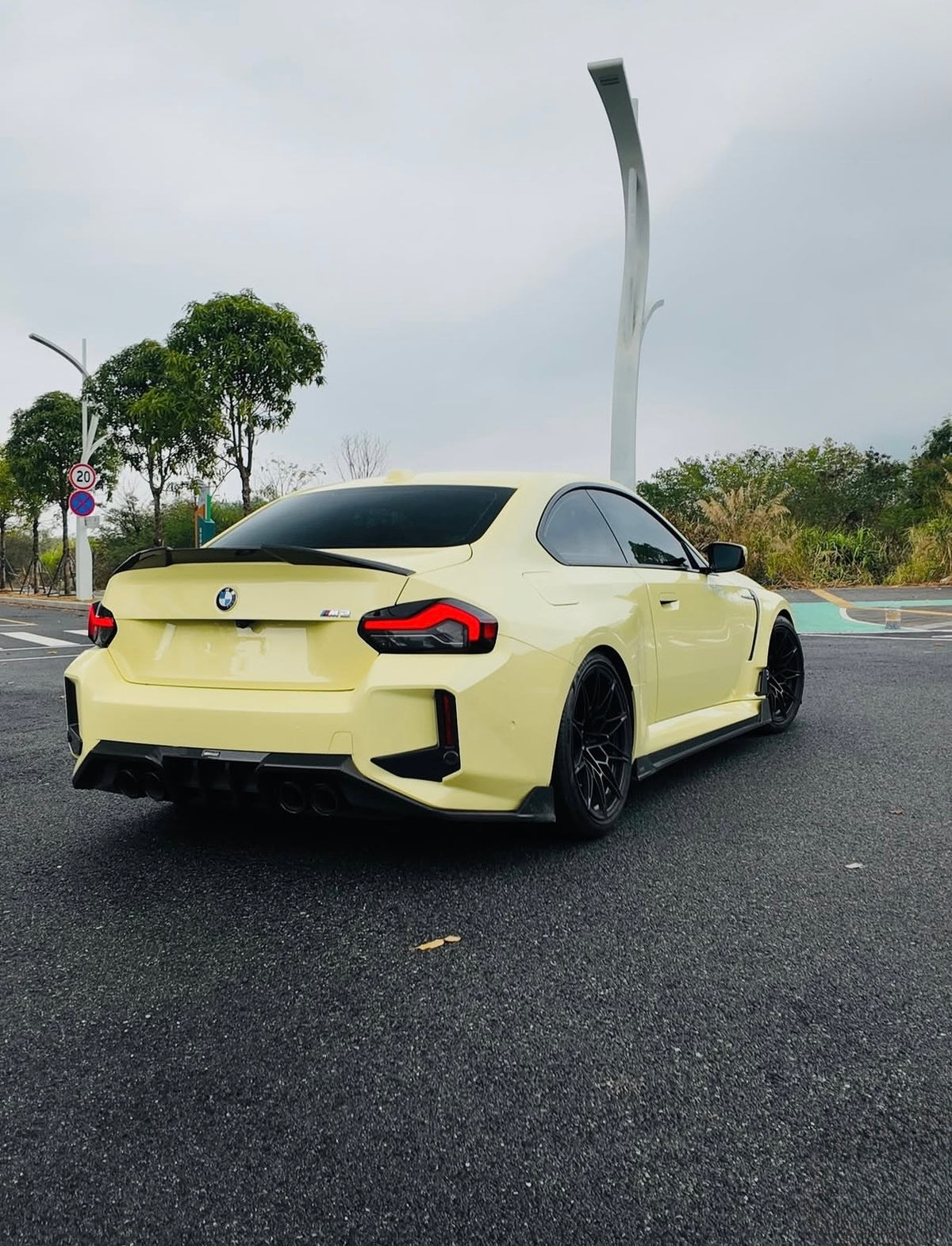Gelber BMW M2 G87 mit RV V1 Heckdiffuser aus Carbon – Heckansicht im Freien