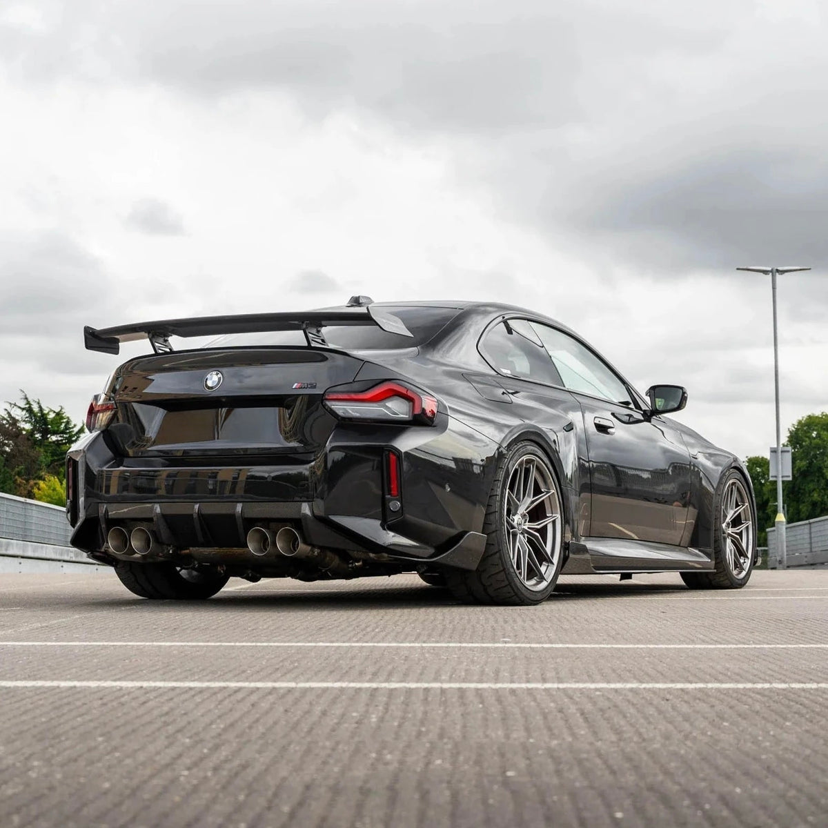 Schwarzer BMW M2 G87 mit CPG + V3 Heckdiffuser – sportliche Heckansicht von der Seite
