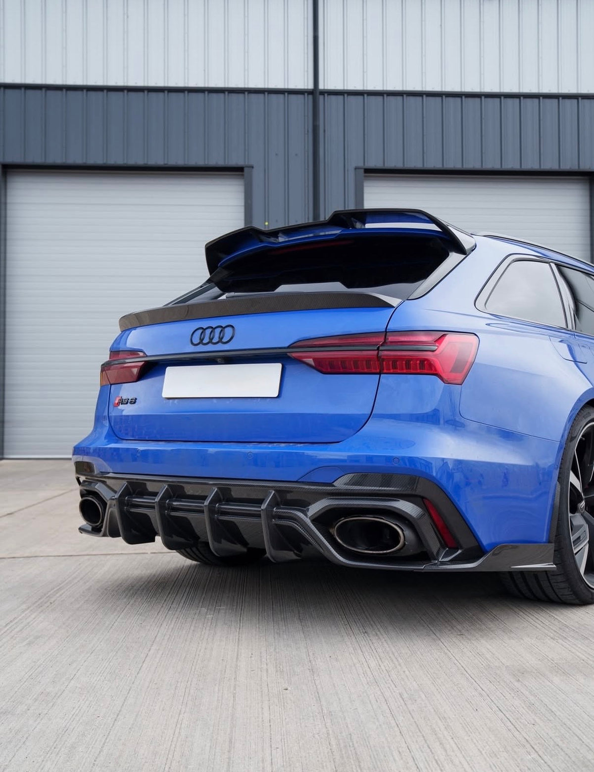 Blauer Audi RS6 C8 Avant mit V1 Dry-Carbon Dachspoiler und sportlicher Heckansicht