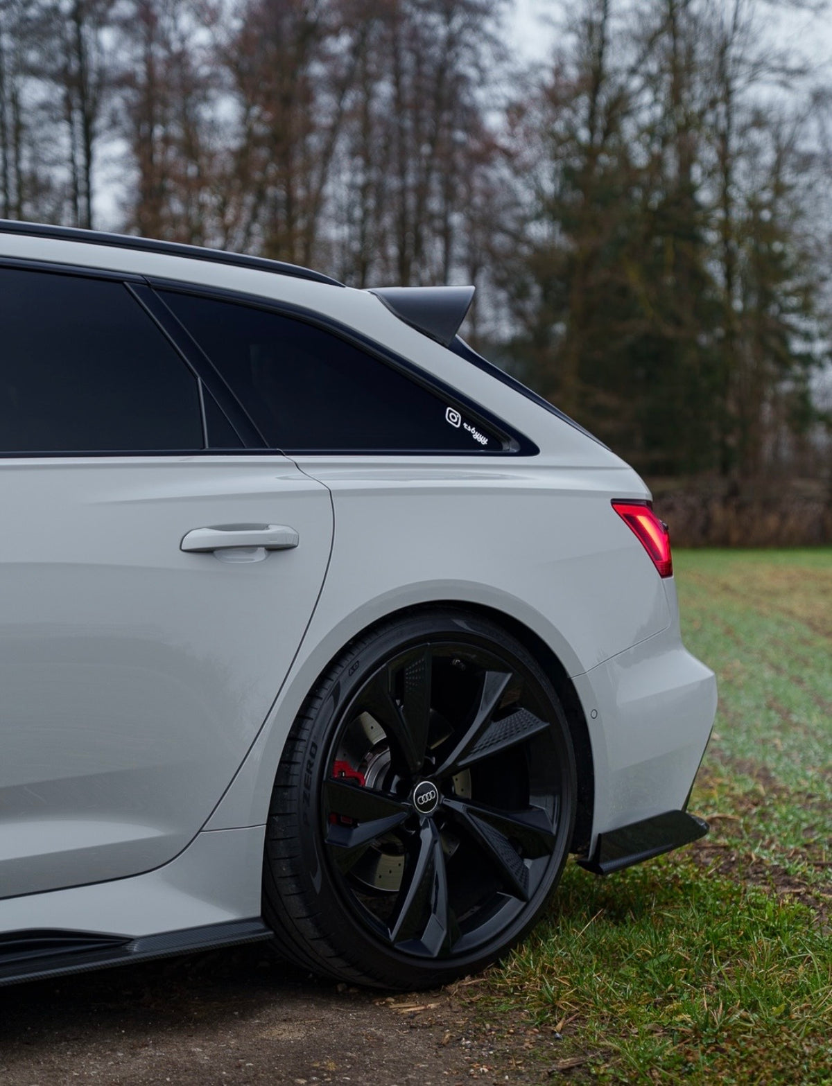 Weißer Audi RS6 C8 Avant mit CPG + V1 Dachspoiler aus Carbon in seitlicher Ansicht
