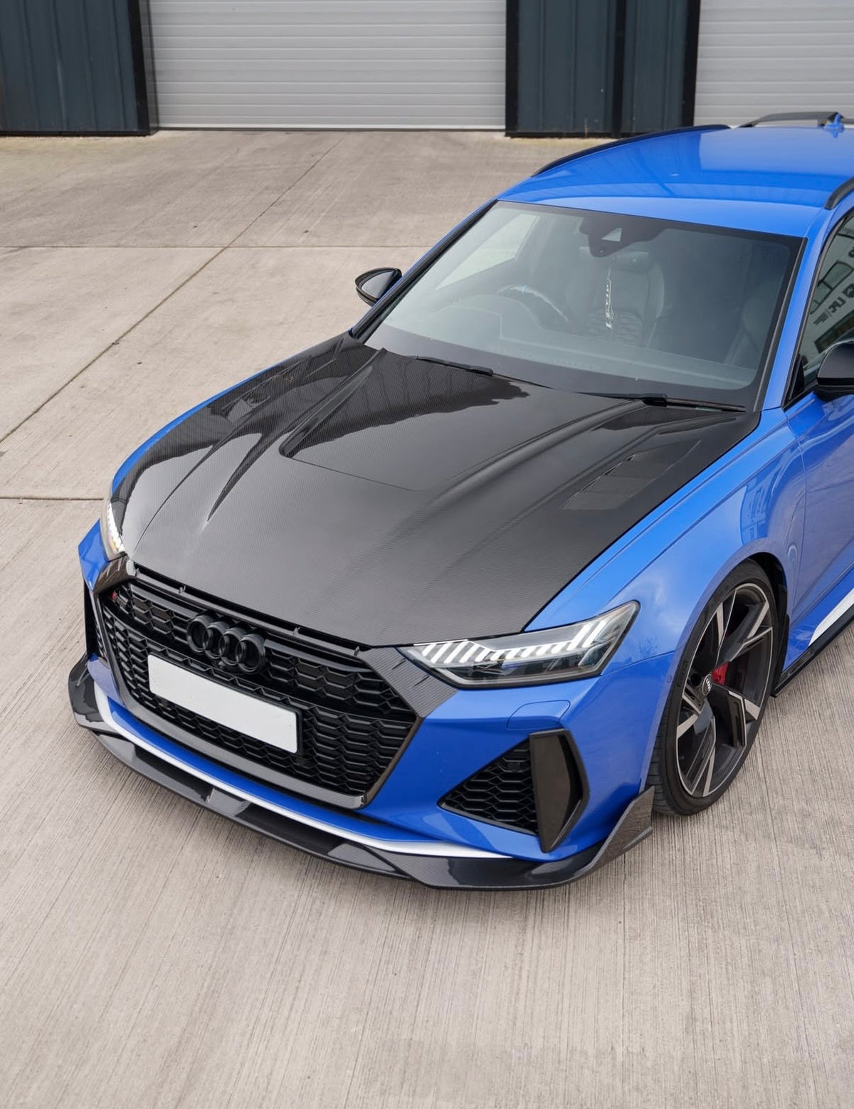 Blauer Audi RS6 C8 mit V1 Carbon Grill-Umrandung in schräger Frontansicht