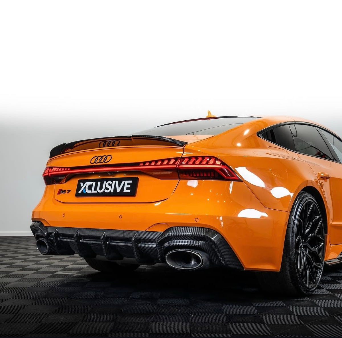 Detailaufnahme des CPG + V1 Carbon Heckspoilers am orangefarbenen Audi RS7 C8 – sportliche Spoilerkante