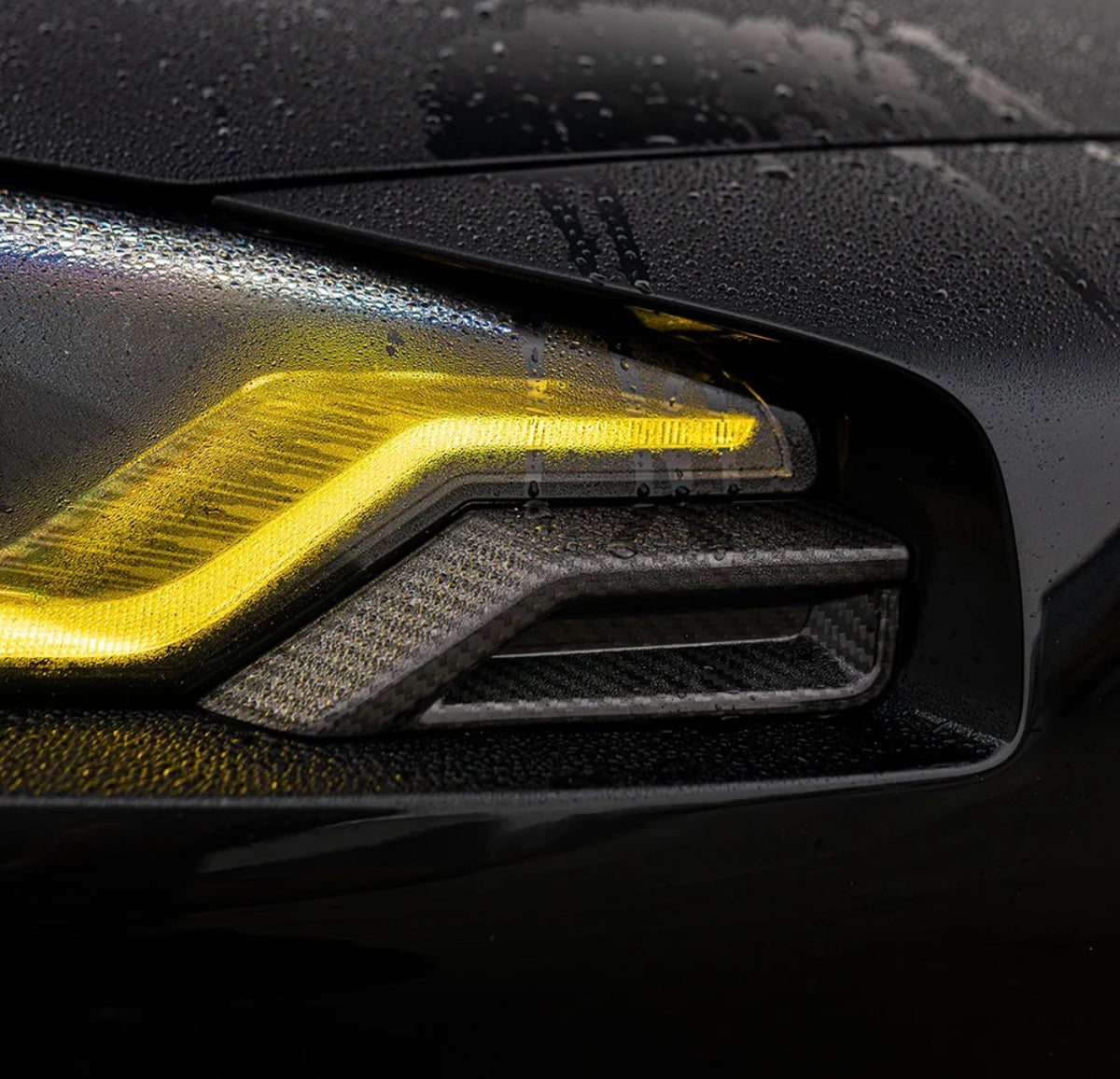 BMW M2 G87 CPG V2 Carbon Scheinwerferaufsätze – Nahaufnahme am schwarzen BMW M2 mit LED-Tagfahrlicht