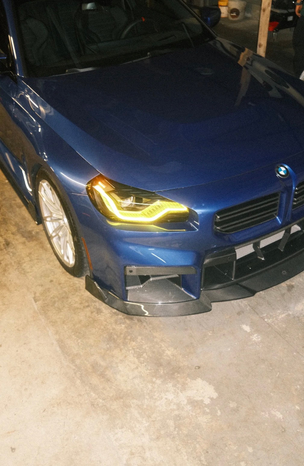 Blauer BMW M2 G87 mit CPG + RV V1 Frontgrill in sportlicher Fahrzeugansicht.
