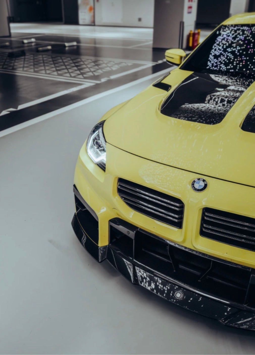 Gelber BMW M2 G87 mit CPG + RV V1 Carbon Frontgrill und sportlichem Lamellendesign.