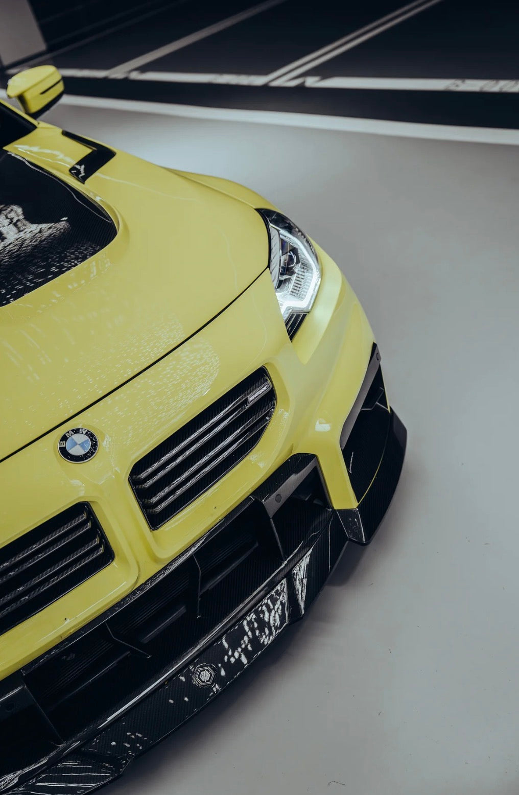 Seitliche Frontansicht eines gelben BMW M2 G87 mit RV V1 Dry-Carbon Kühlergrill.