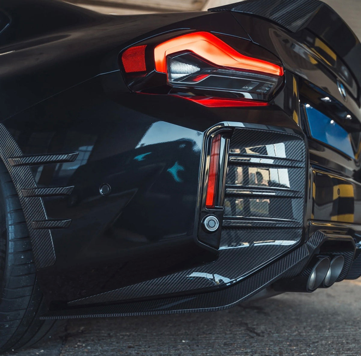 Detailansicht der montierten V2 Dry-Carbon Heckstoßstangeneinsätze am BMW M2 G87