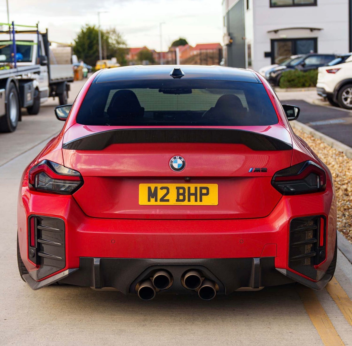 Roter BMW M2 G87 mit CPG + V2 Dry-Carbon Heckstoßstangeneinsätzen von hinten