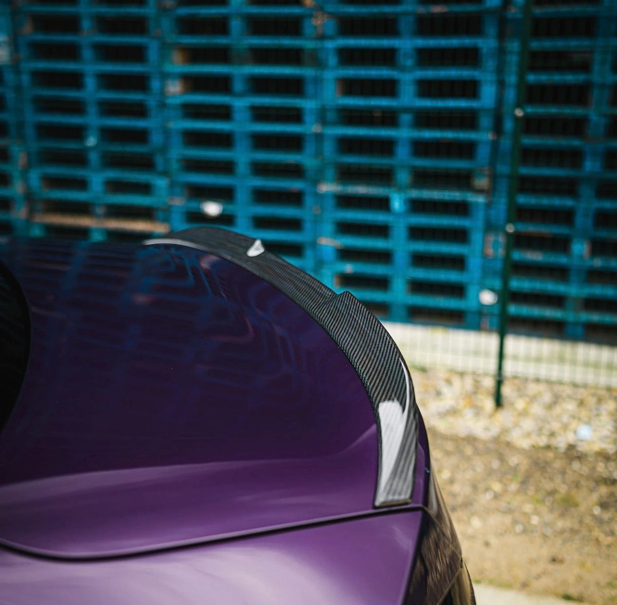 Detailansicht des V3 Carbon Heckspoilers auf dem Kofferraumdeckel eines lila BMW M2 G87