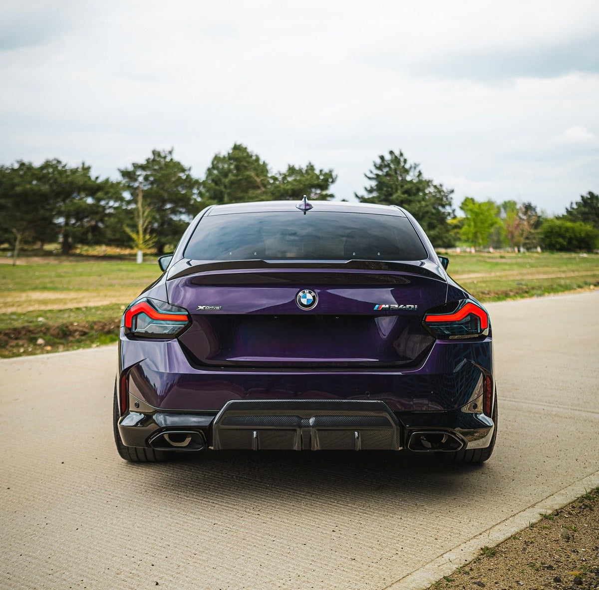 Lila BMW M2 G87 mit montiertem CPG + V3 Dry-Carbon Heckspoiler in Heckansicht