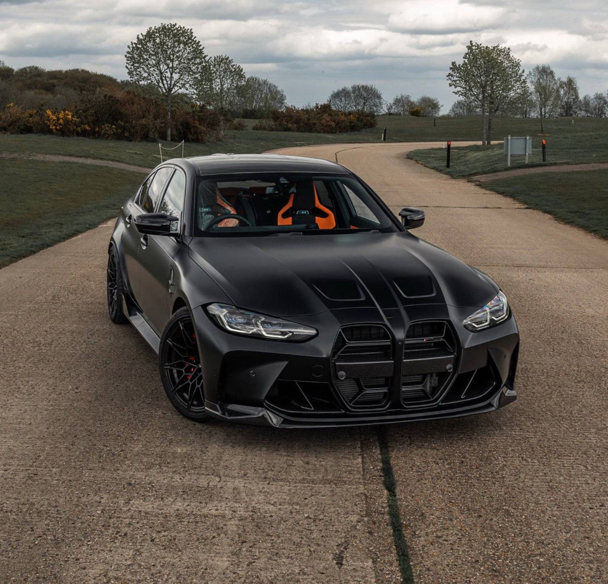 Schwarzer BMW M3 G80 mit CPG+ MP V4 Frontlippe aus Dry-Carbon in sportlicher Frontansicht