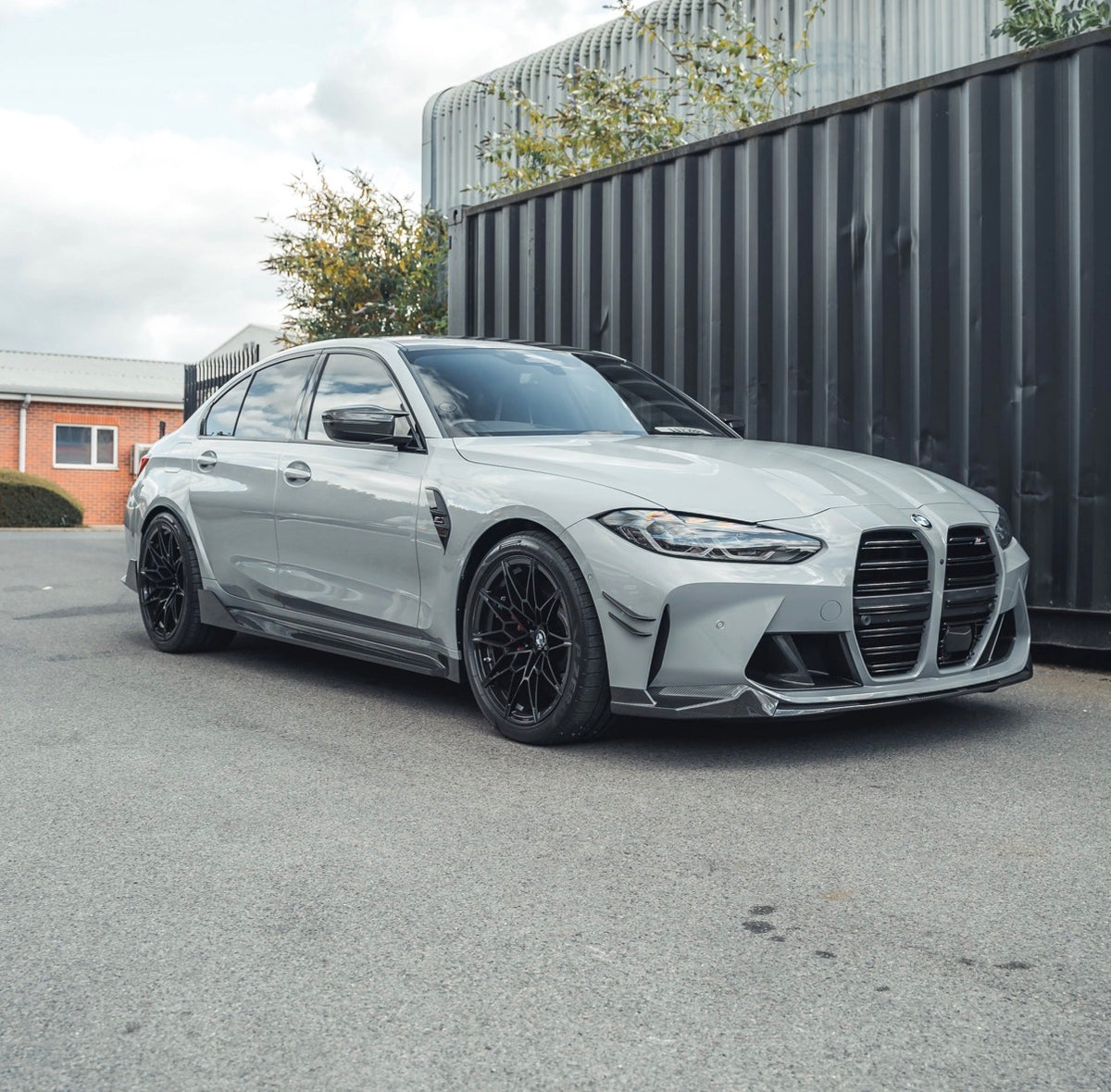 Silberner BMW M3 G80 mit montierter CPG+ MP V4 Carbon Frontlippe in der schrägen Frontansicht