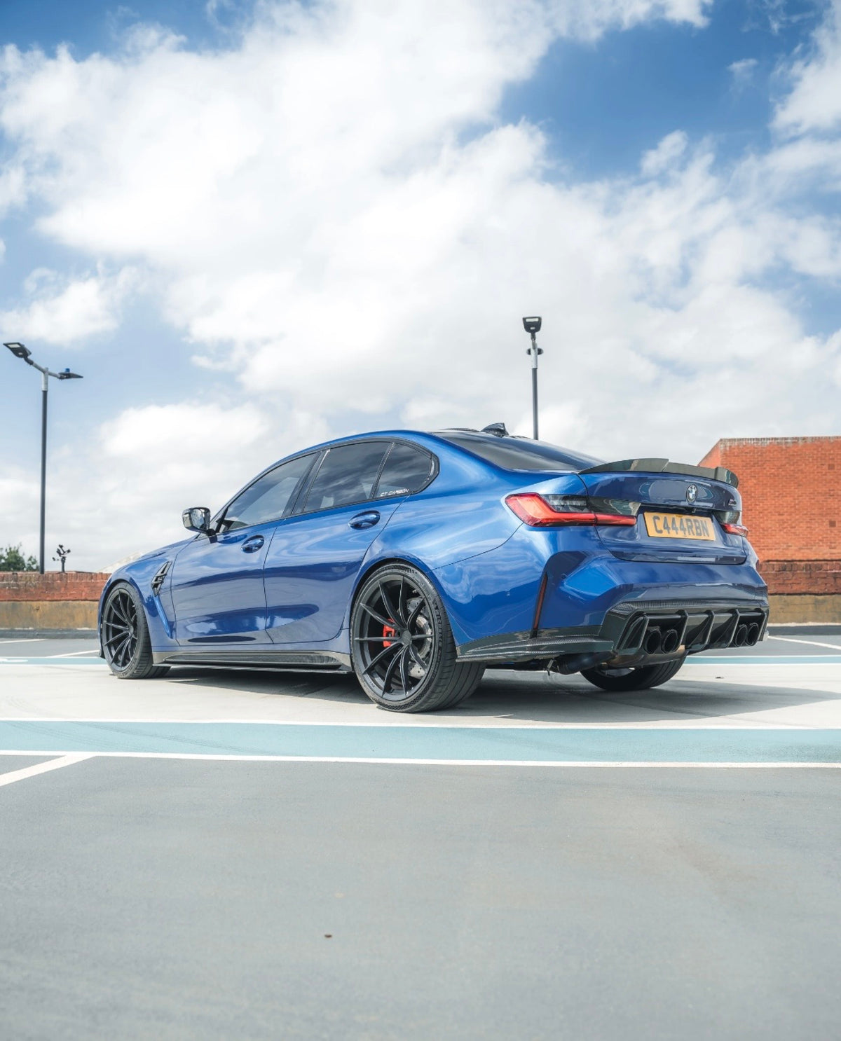 Blauer BMW M3 G80 mit CPG+ V3 Dry-Carbon Heckdiffuser und Sideblades in sportlicher Heckseitenansicht