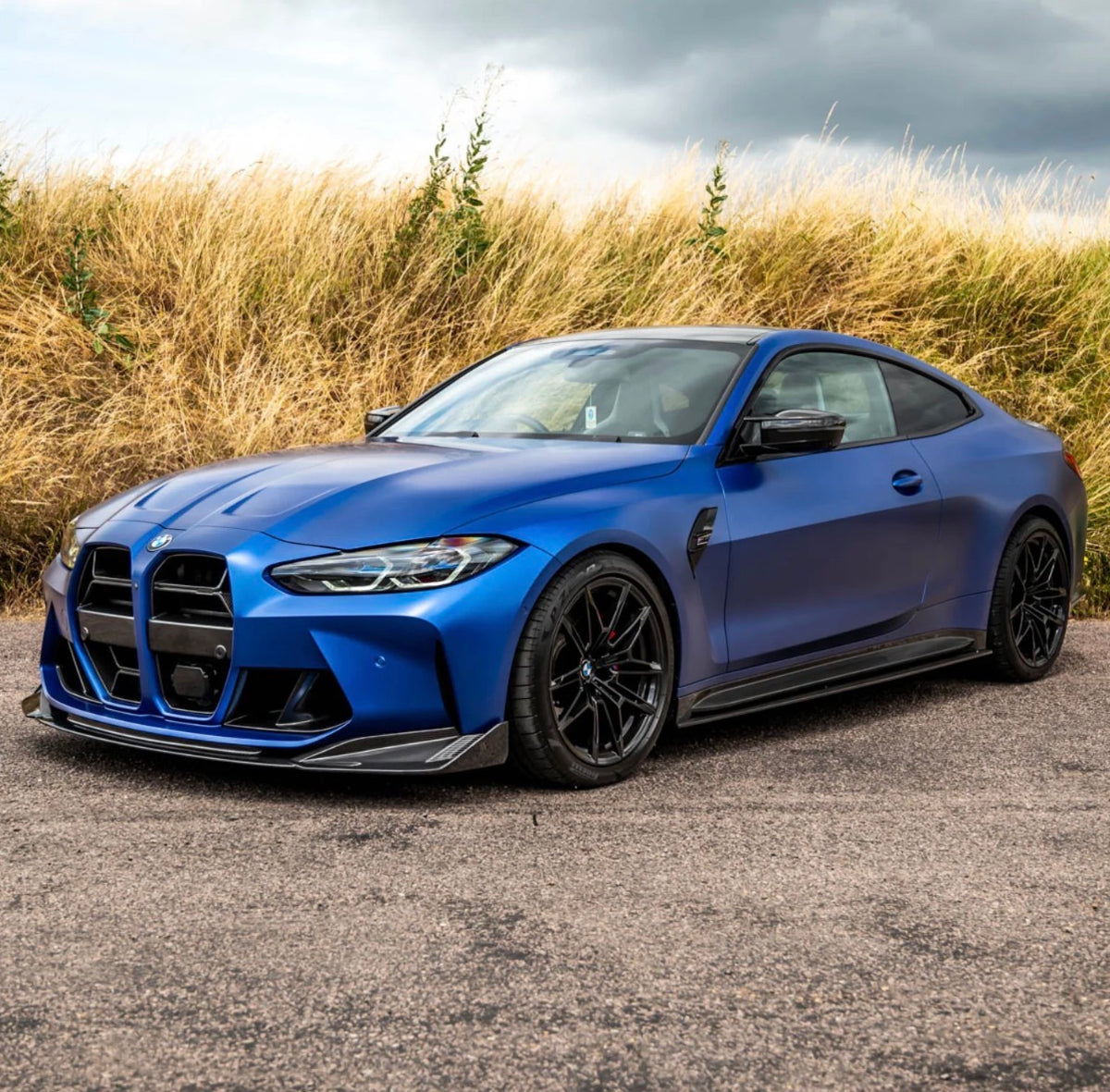 Blauer BMW M3 G80 mit CPG+ V6 Seitenschweller-Set inklusive Carbon Seitenschwelleransätzen in schräger Frontansicht