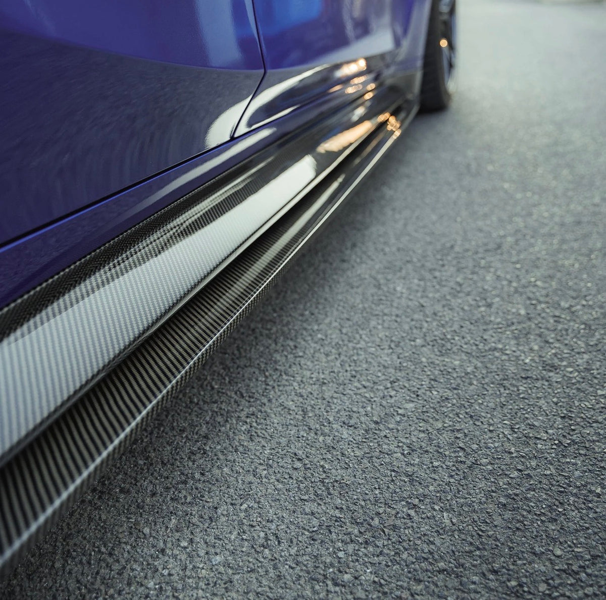 Detailansicht der CPG+ V6 Carbon Seitenschweller und Seitenschwelleransätze am blauen BMW M3 G80