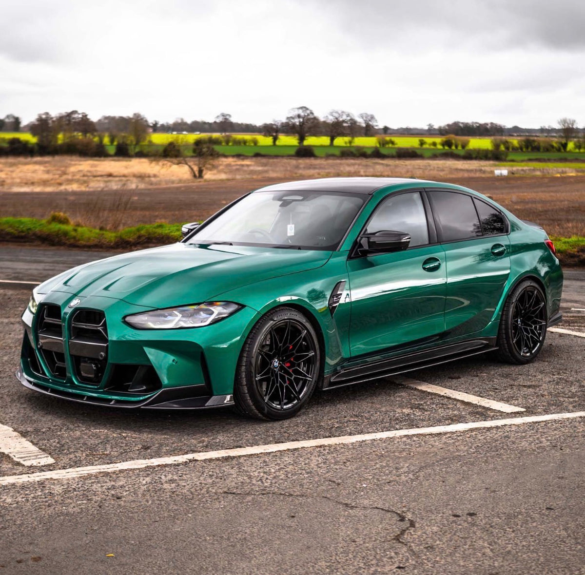 Grüner BMW M3 G80 mit montierten CPG+ V6 Carbon Seitenschwellern in sportlicher Seitenansicht