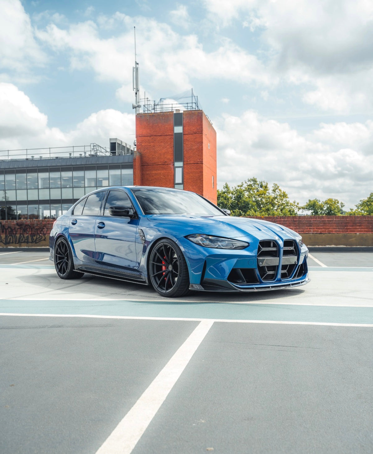 Blauer BMW M3 G80 mit CPG+ V6 Seitenschweller-Set aus Dry-Carbon in schräger Frontansicht