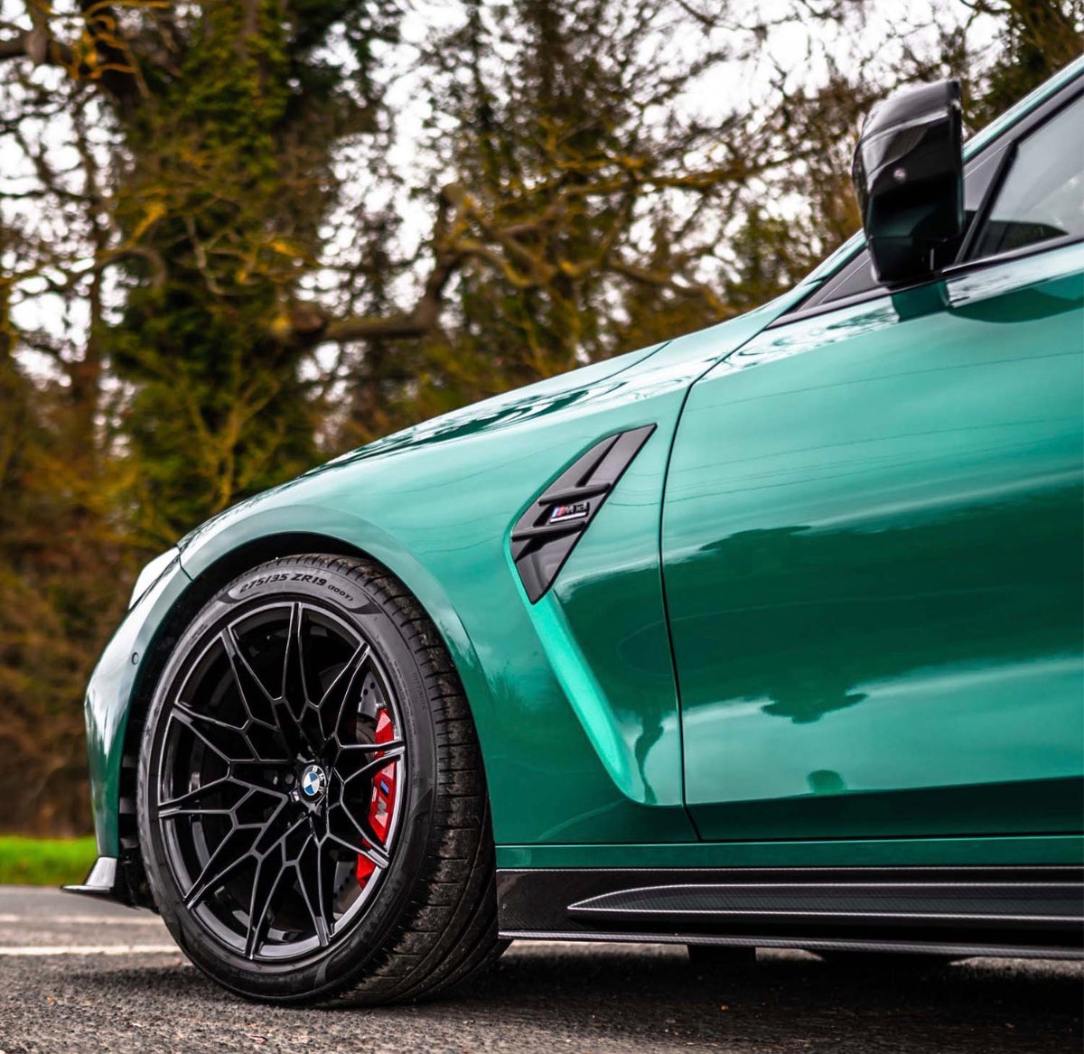 Detailaufnahme der V6 Dry-Carbon Seitenschweller und Seitenschwelleransätze am grünen BMW M3 G80
