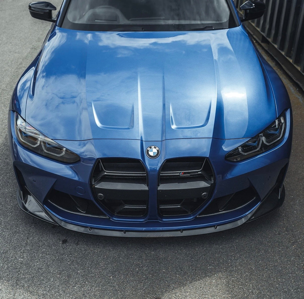 Blauer BMW M3 G80 mit V7 Carbon Frontspoiler von CPG x Car THINGS LTD in der Vorderansicht