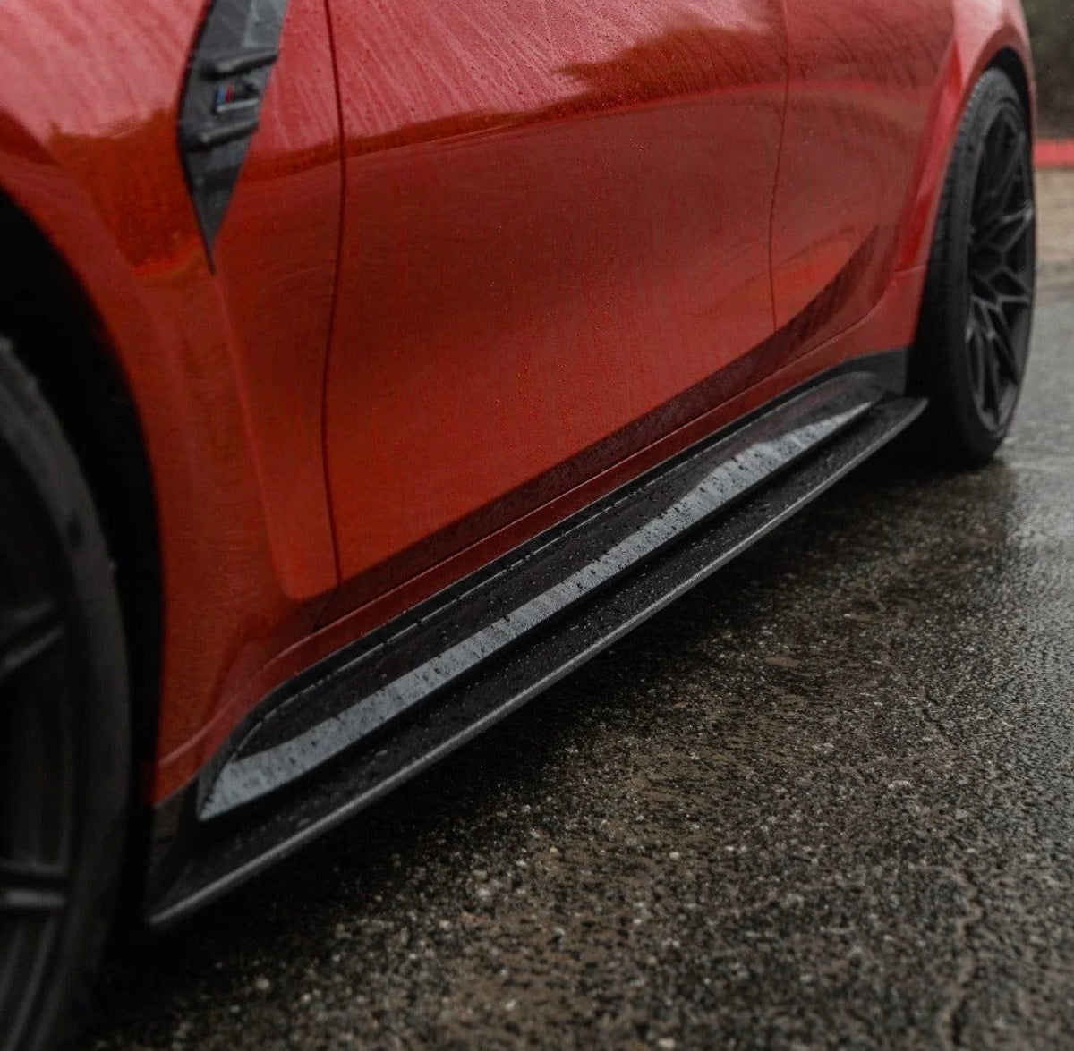 Roter BMW M3 G80 mit montierten CPG+ V7 Carbon Seitenschwelleransätzen in seitlicher Detailansicht