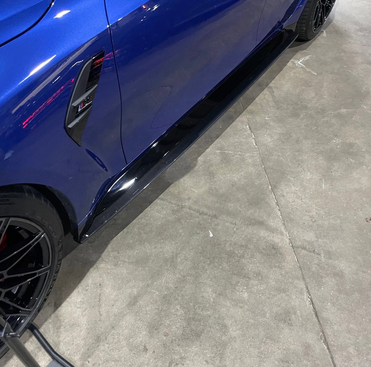Seitliche Detailaufnahme der V7 Dry-Carbon Seitenschwelleransätze am blauen BMW M3 G80