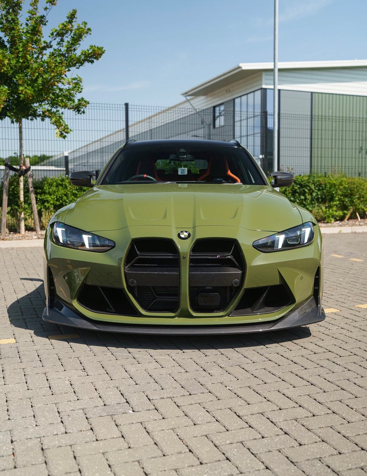 Grüner BMW M3 G80 mit montierter CPG+ V8 Carbon Frontlippe in der Vorderansicht