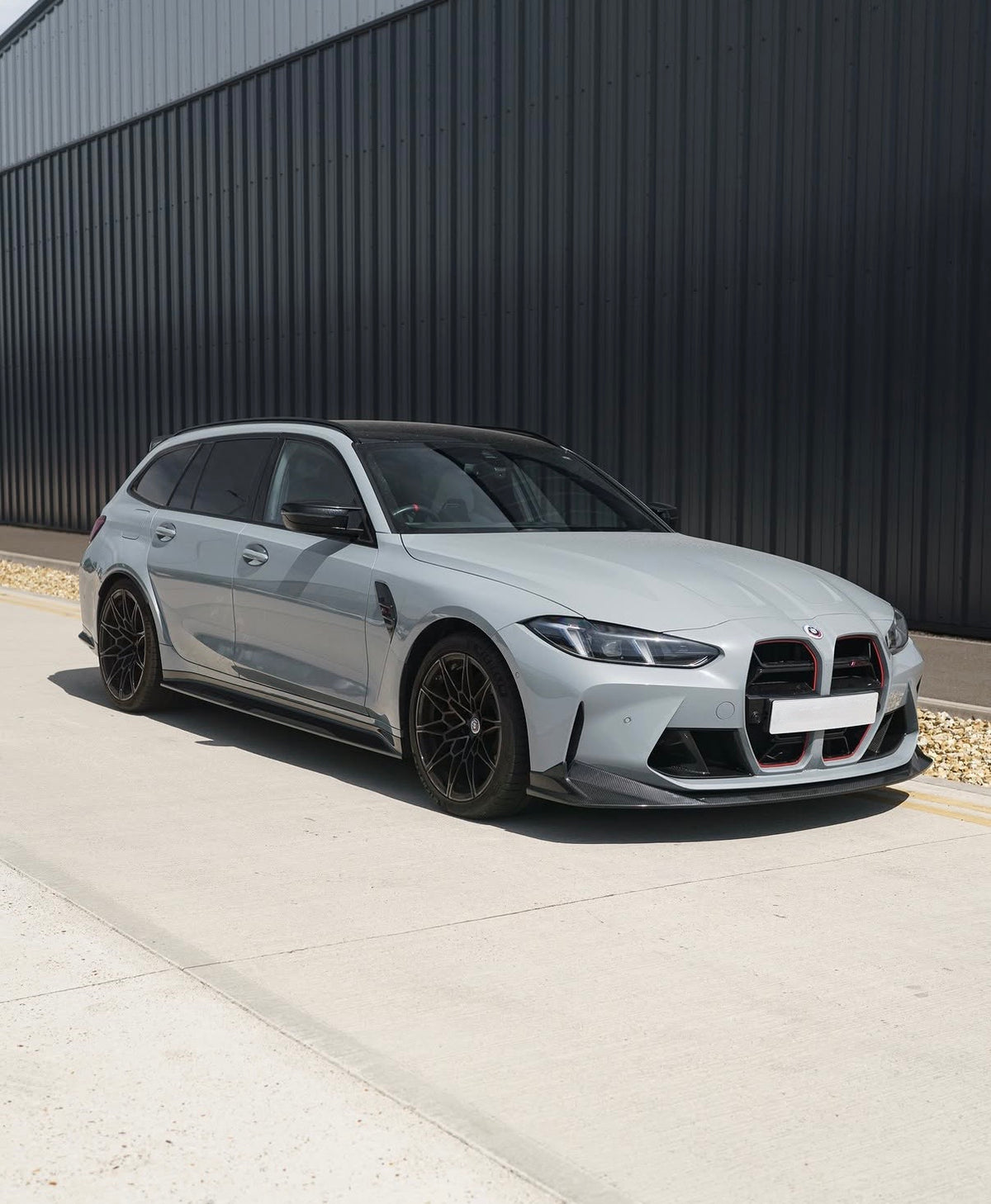 Weißer BMW M3 G80 mit CPG+ V8 Frontlippe aus Dry-Carbon in der seitlichen Frontansicht