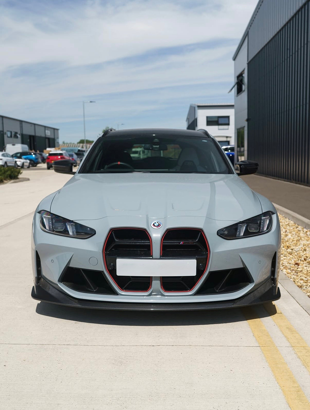 Weißer BMW M3 G80 mit montierter V8 Carbon Frontlippe von Carbon Parts Germany in der Vorderansicht