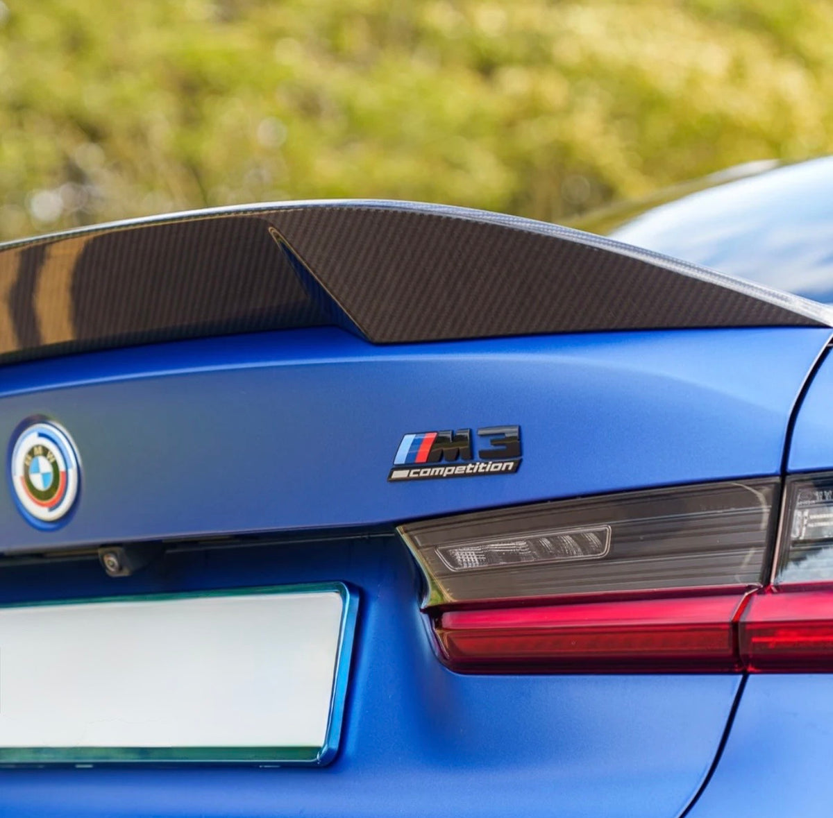 Montierter CPG + V8 Heckspoiler aus Dry-Carbon auf dem BMW M3 G80 mit M3 Emblem