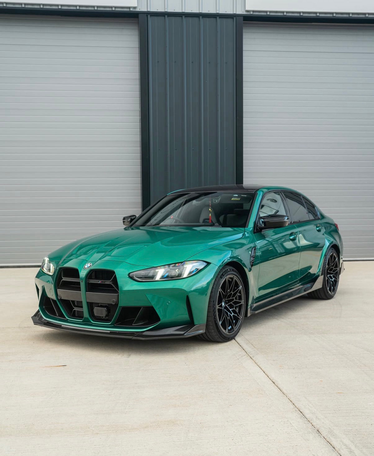Grüner BMW M3 G80 mit CPG+ V9 Dry-Carbon Seitenschwellern in schräger Frontansicht