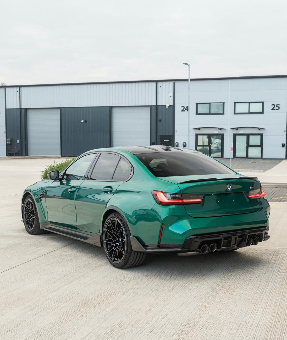 Grüner BMW M3 G80 mit CPG+ V9 Dry-Carbon Seitenschwellern in schräger Heckansicht