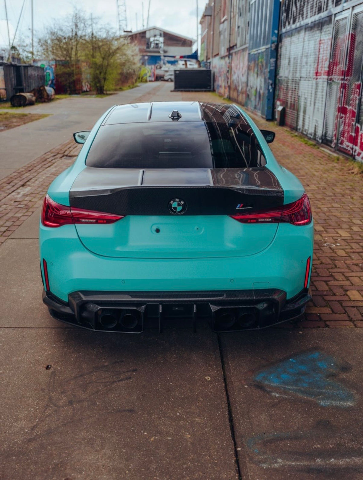 BMW M4 G82 in Türkis mit Heckdiffuser in der Heckansicht