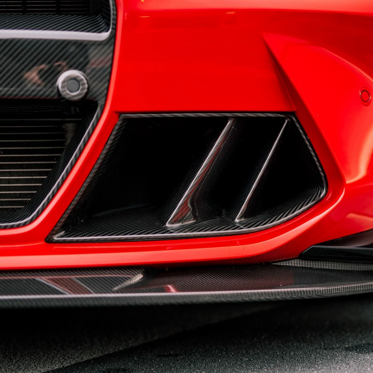 CPG+ V3 Carbon Lufteinlass an roter BMW M Frontstoßstange – Nahaufnahme