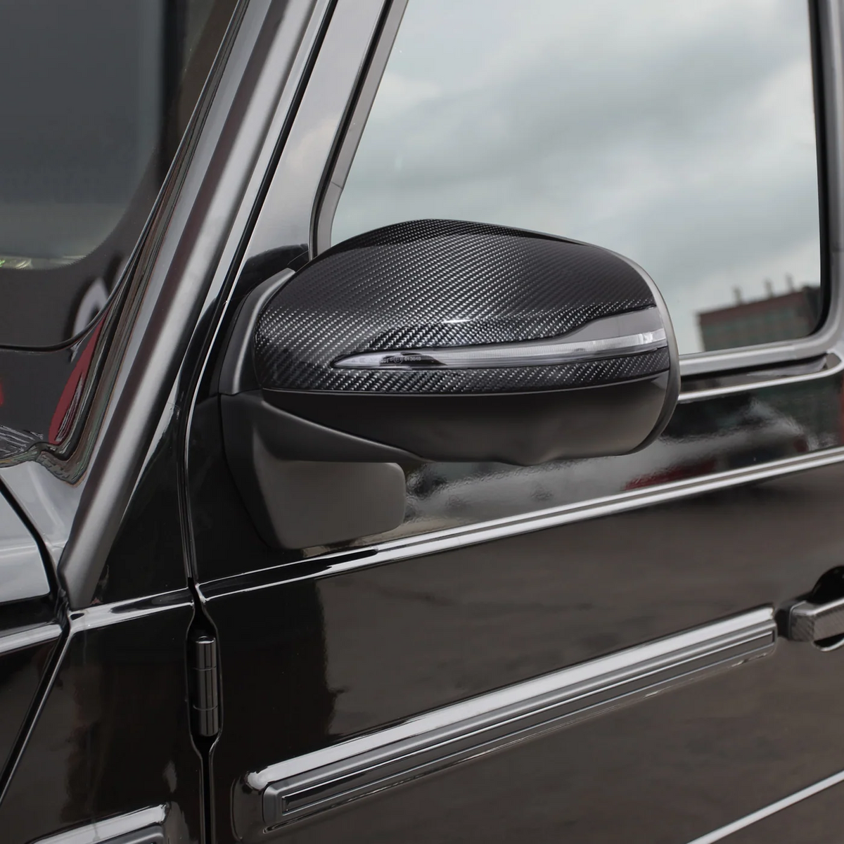 CPG + Carbon Spiegelkappe an einer Mercedes-Benz G-Klasse montiert – hochwertige Dry-Carbon-Optik am Außenspiegel mit integrierter Blinkerleiste