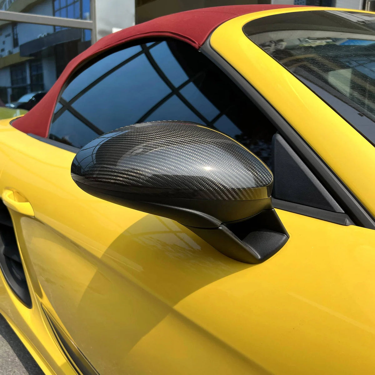 Carbon Spiegelkappe am Porsche 718 Cayman 982 montiert – Detailaufnahme der glänzenden Carbonfaserstruktur
