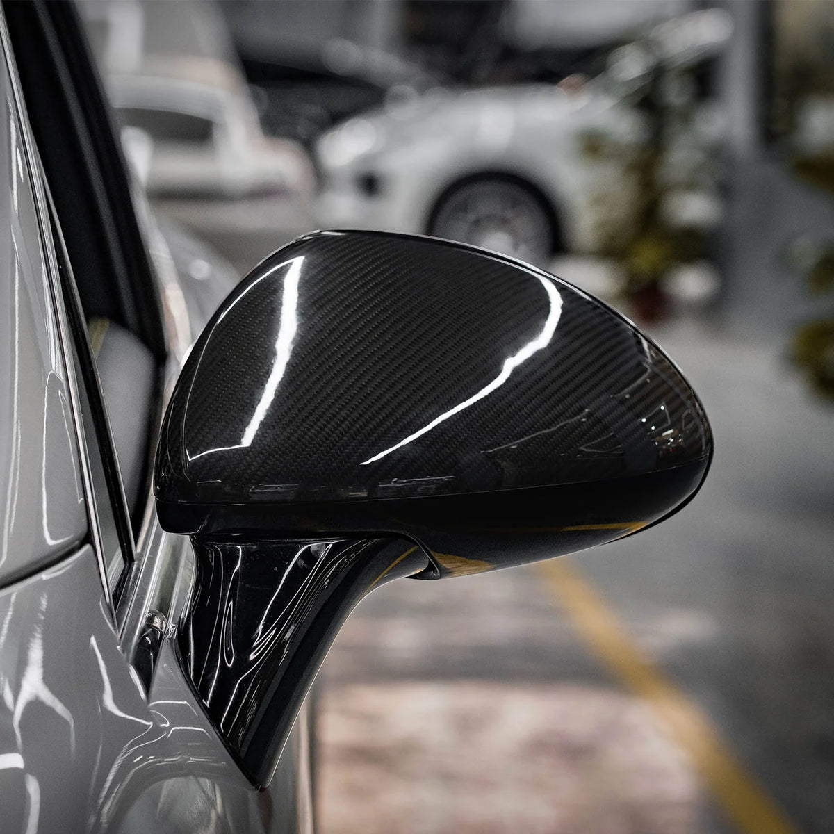 Carbon Spiegelkappe am Porsche Cayenne 958.1 montiert – Nahaufnahme des Außenspiegels mit glänzendem Carbonfinish