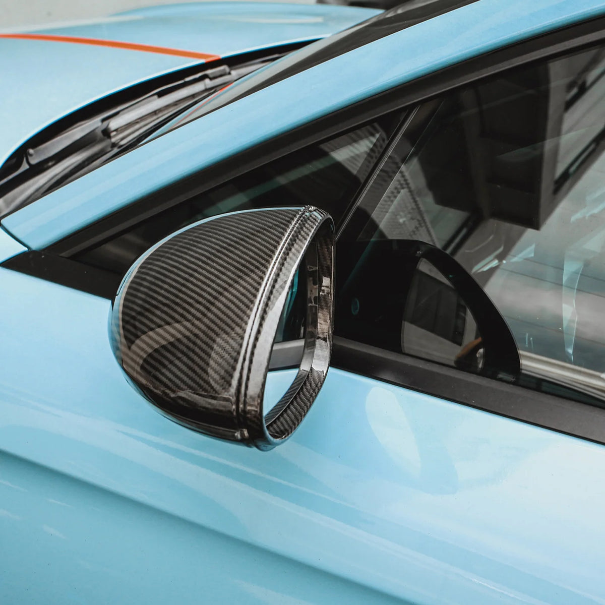 Carbon Spiegelkappe an einem blauen Porsche Panamera 971 montiert – Nahaufnahme des Außenspiegels mit sichtbarer Carbonfaserstruktur